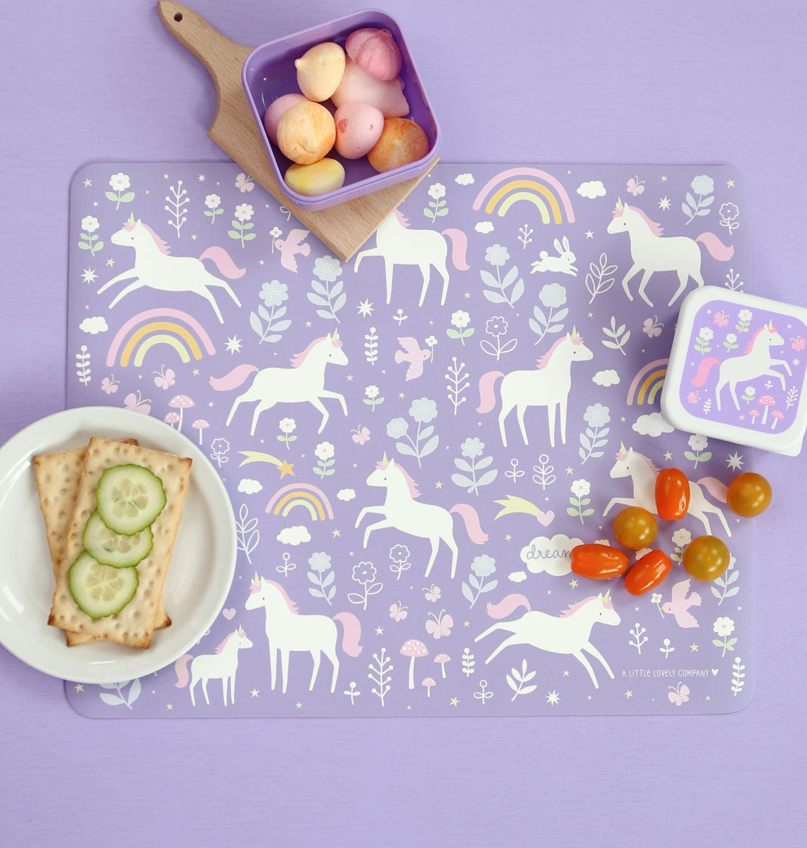 paarse placemat met eenhoorn print tijdens lunch met broodbakjes en drinken
